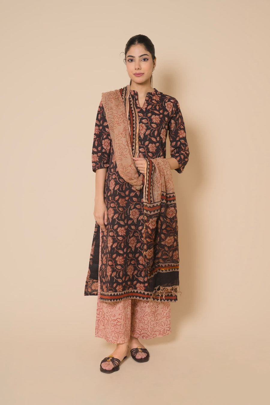 Woman in a brown floral block print kurta set with a printed dupatta