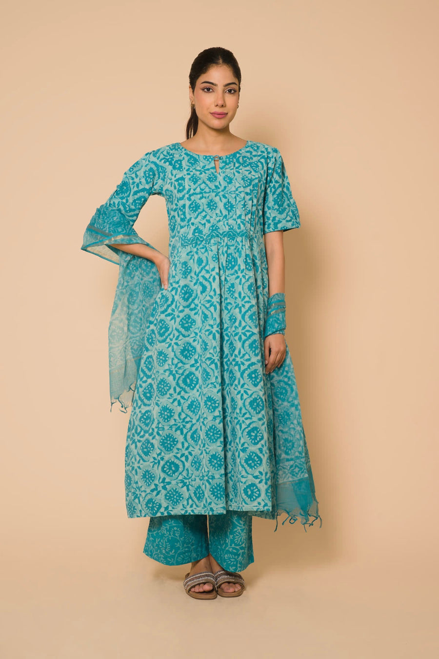 Woman in a teal print anarkali kurta set